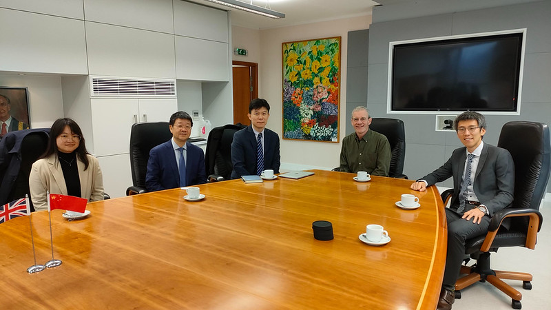 Visitors from Fudan University sitting around a boardroom table drinking tea/coffee with University of Bath academics
