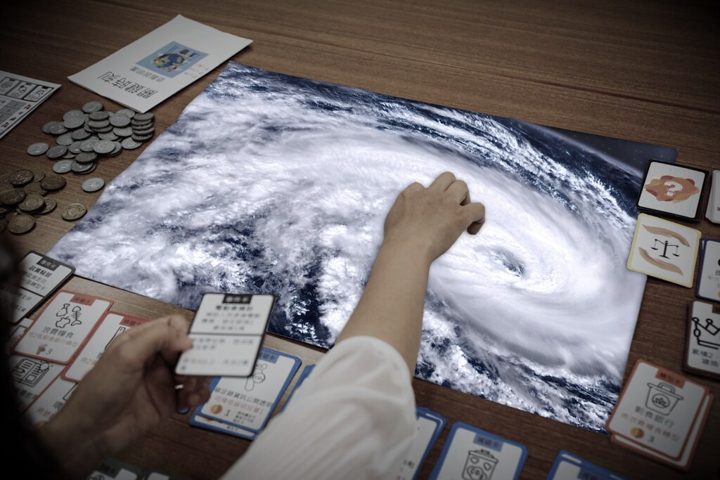 桌面上琳瑯滿目的遊具，具象呈現氣候變遷相關的災害與應變方法。攝影：蔡宗儒；畫面設計：陳靖宜