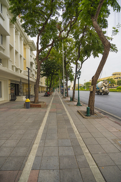 Sidewalk with trees along Ratchadamnoen Klang road in Bangkok, Thailand