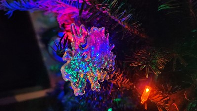Snowflake ornament illuminated by Christmas tree lights