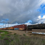 Rainbow over BNSF Manifest A rainbow forms over storm clouds from a recent rain storm moving through Northern California. I was busy shooting the train from the opposite angle when I turned around and quickly grabbed this shot. The clouds were wonderful on this December afternoon in Modesto.