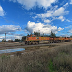 BNSF 5072 Westbound A mixed manifest rolls through Modesto Amtrak Station under a beautiful cloudy winter sky after a storm rolled through Northern California. 