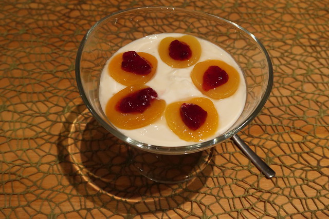 Preiselbeeren auf Aprikosenhälften auf mit Honig gesüßtem Joghurt