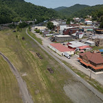 20230525-USDA-RD-WV-LSC-0752 Aerial view of the former train station in downtown Gassaway, WV, on May 25, 2023.

The new Elk River Trails, part of the Pioneer Trails Network runs through Gassaway. This trail follows a former railway and train station that has now been transformed into an event center with an event field and bandstand. It connects various towns and offers scenic pathways, making it an ideal spot for hikers, bikers, and runners to enjoy the beautiful surroundings.
       The 73-mile Elk River trail winds through Braxton and Clay County, and the 102-mile Elk River Water Trail flows from Sutton to Charleston, WV. These trails are included in the Pioneer Trail Network that connects to the Ohio River. A study stated that for the Elk River Trails, a 4-million dollar investment into the four trail towns of Gassaway, Clay, Sutton, and Clendenin during the next 10 years could result in more than 390 million dollars in economic impact in the region over 15 years. 
The river provides excellent fishing opportunities and is ideal for leisure floating and kayaking. Unlike the whitewater rivers in West Virginia, this river is family-friendly and can be safely navigated by users of all ages and abilities. Nicholas and Webster counties are both working on enhancing their recreation amenities and improving connectivity to Snowshoe Resort to take advantage of an established recreation hub. Every county or community has the opportunity to create recreation-related businesses such as rental shops, restaurants, and commercial and lodging establishments and to showcase local artisans, musicians, and unique town history. 
This project aims to provide infrastructure and support services for community and economic development in all trail town communities within the Pioneer Network. The goal is to develop trail towns in the Pioneer Network region by leveraging the state&#039;s thriving tourism industry. The approach will be comprehensive and regional, with an emphasis on distressed counties. It will include infrastructure development, facility construction, and ancillary activities necessary to create prosperous and thriving communities. The strategies used will address various needs identified by communities and can involve county, state, and federal entities.
The strategy builds on the success of Advantage Valley&#039;s FASTER WV initiative to facilitate the start-up and expansion of businesses with:
1.Develop marketing materials to recruit Elk River Trails entrepreneurs and support existing businesses. 
2.Place business outreach ambassadors in Braxton and Clay Counties to recruit and link entrepreneurs to FASTER WV and other resources.
3.Provide coaching and technical assistance awards to help entrepreneurs&#039; start-up efforts. These awards can support training, marketing, and other essential aspects of starting a business.
4.Implement community improvement projects to make the trail towns more attractive for tourists. 
5.Implement a façade renovation grant program for &amp;quot;Main Street&amp;quot; businesses.


Their strategy is supported by the U.S. Department of Agriculture (USDA), Rural Development (RD), Rural Partners Network (RPN) SMART project approach. This approach has four key strategies, namely: 
1. Building on each region&#039;s competitive advantage and leveraging the marketplace 
2. Establishing and maintaining a robust regional infrastructure 
3. Creating revitalized, healthy, and resilient communities 
4. Developing talented and innovative people.

-----

RPN
The Rural Partners Network (RPN) is a government program that aims to assist rural communities in finding resources and funding to create job opportunities, build infrastructure, and support long-term economic stability. This network comprises federal agencies and commissions that work directly with rural communities to enhance their prosperity through job creation, infrastructure development, and community improvement. Led by USDA Rural Development, members of the RPN collaborate to identify resources to help rural people build the futures they envision for the unique places they call home.

RPN deploys federal staff to selected RPN Community Networks located across the United States. These RPN Liaisons collaborate with small, rural communities to understand their needs and the importance of leveraging the programs and resources of various funders and assistance providers to achieve their goals. The Liaisons provide assistance to local individuals in navigating programs, building relationships, and identifying community-driven solutions.

Participating RPN agencies and offices (rural.gov/about#block-views-block-partners-partners-listing) are also joining forces to promote rural priorities as federal programs and policies are developed to address funding gaps, increase access to technical assistance and ensure equitable access to federal funding.

For more information, please go to RURAL.gov, the official website of the Rural Partners Network.

USDA Media by Lance Cheung.