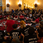 CA_CapitalRotunda_Ceasefire_IMG_0415-1 Jews lead powerful call for CEASEFIRE
- CA State Capital - January 3, 2024

With a silent signal, hundreds in the rotunda of the state capital quietly moved into place, revealed previously hidden black t-shirts, laid out a banner and sat down around it as, above them, long banners were unfurled from the balcony. Those sitting around the floor banner began the process of creating over 1000 red and black tissue paper poppies which were laid on top of the banner which read - &amp;quot;30,000 KILLED IN PALESTINE - Each Poppy Represents 20 Palestinian Lives&amp;quot;. As the poppy-making began, so did the singing.

At the same time, hundreds filled the gallery of the State Assembly, also singing chants and dropping banners, causing the first session to eventually adjourn.

___

Led by Jewish groups, hundreds of Jews and allies came together today at the California State Capital with banner drops, chants and beautiful song to call on legislators, on their first day back in session, to support an immediate and permanent CEASEFIRE in Gaza and to stop the US funding - and CA taxpayer funding! - of genocide.

Instead... Invest in:

Healthcare
Schools,
Housing
Our Planet
Community