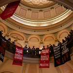CA_CapitalRotunda_Ceasefire_IMG_0488-1 Jews lead powerful call for CEASEFIRE
- CA State Capital - January 3, 2024

With a silent signal, hundreds in the rotunda of the state capital quietly moved into place, revealed previously hidden black t-shirts, laid out a banner and sat down around it as, above them, long banners were unfurled from the balcony. Those sitting around the floor banner began the process of creating over 1000 red and black tissue paper poppies which were laid on top of the banner which read - &amp;quot;30,000 KILLED IN PALESTINE - Each Poppy Represents 20 Palestinian Lives&amp;quot;. As the poppy-making began, so did the singing.

At the same time, hundreds filled the gallery of the State Assembly, also singing chants and dropping banners, causing the first session to eventually adjourn.

___

Led by Jewish groups, hundreds of Jews and allies came together today at the California State Capital with banner drops, chants and beautiful song to call on legislators, on their first day back in session, to support an immediate and permanent CEASEFIRE in Gaza and to stop the US funding - and CA taxpayer funding! - of genocide.

Instead... Invest in:

Healthcare
Schools,
Housing
Our Planet
Community