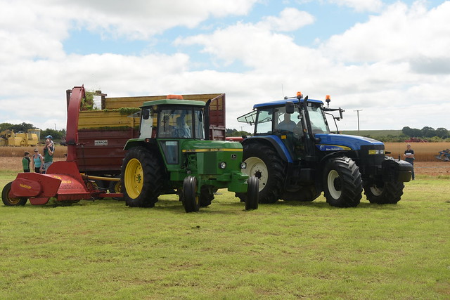 John Deere 3040 Tractor with a Tarrup Precision Chop Forage Harvester filling a Herron Silage Trailer drawn by a New Holland TM155 Tractor