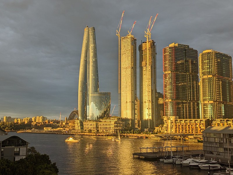 A photograph of the Barangaroo skyscrapers lit yellow by the last of the sun, with Darling Island already in the dark