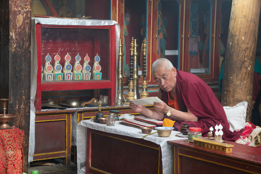 Монах читает пуджу в храме
