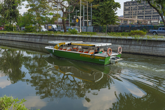 Electric boat on Khlong Phadung Krung Kasem with reflections in Bangkok, Thailand