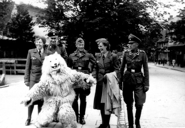 Member's of the Waffen-SS and Helferin pose with the iconic 'Eisbär' during WW2