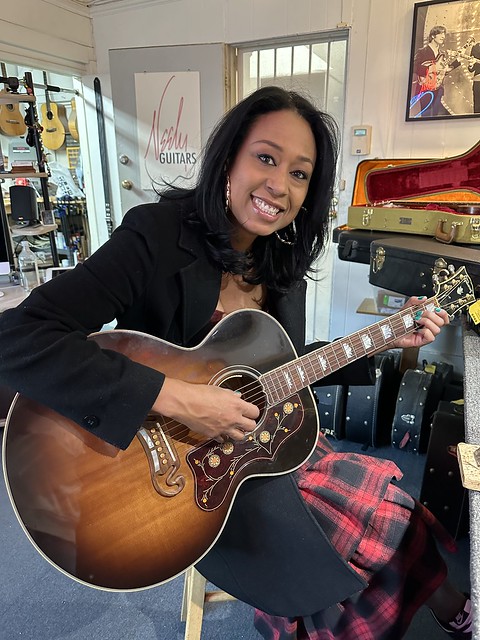 Here's the beautiful and multitalented Carmel Helene picking up her guitar after corrections and set up. She's been a wonderful client for almost 20 years now!