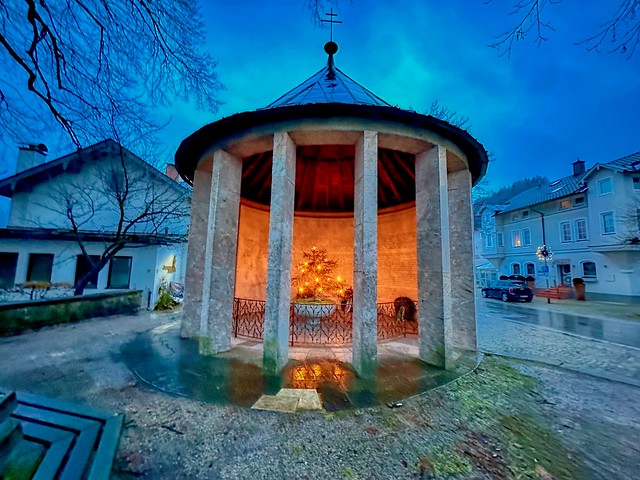 A warm orange glow emanating from the memorial to the war victims on a cold winter morning in Kiefersfelden in Bavaria, Germany