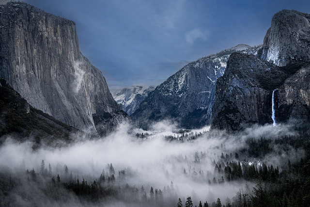 Yosemite Valley draped in ethereal fog and snow, a mystical fusion of nature's elements.