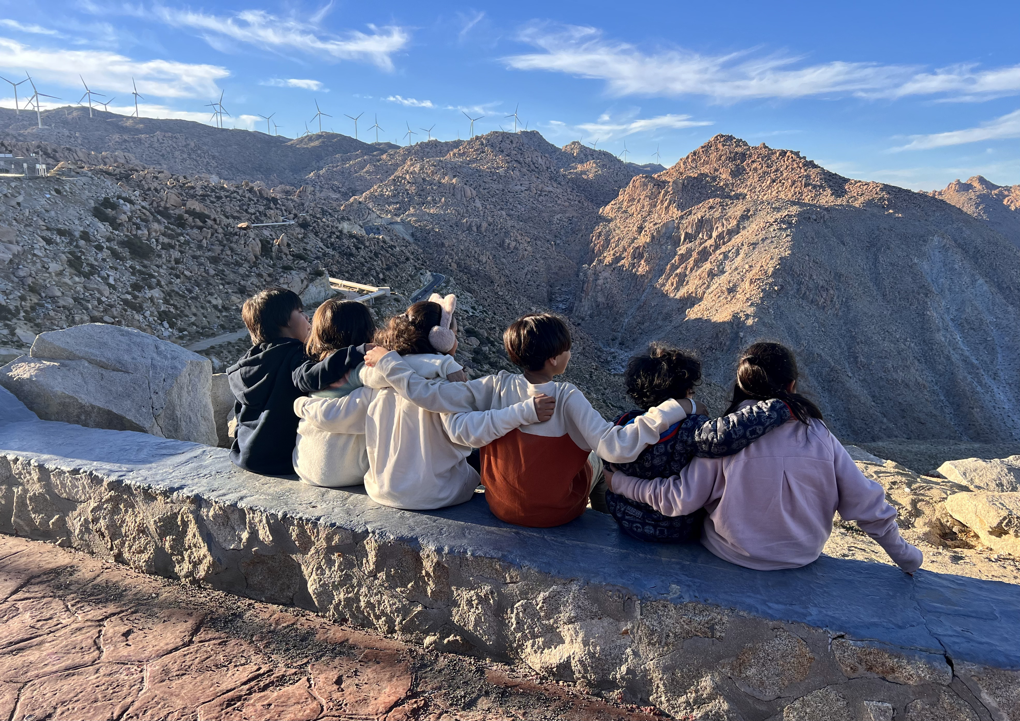 Niños sentados juntos observando las montañas