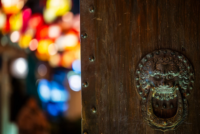 Chinese door knocker against chinese lanterns illuminated at night