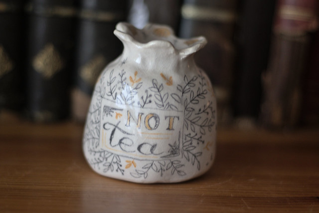 Petit pot en faïence blanche avec décor végétal au crayon à oxyde, inscription Not tea