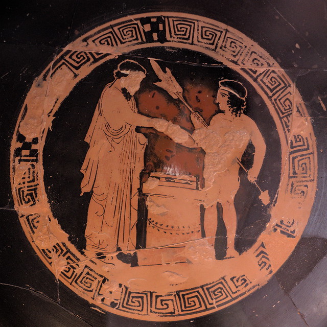 Athenian Red Figure kylix (cup) representing a draped man and a youth with a spit at an altar (Vatican 35262)