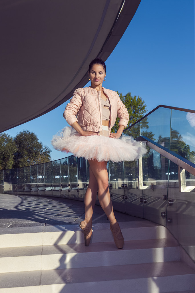 Dance Ideas. One Winsome Sexy Slim Professional Caucasian Ballet Dancer in Pink Tutu Dress Posing in Standing Pose With Straight Legs