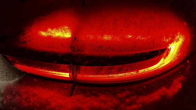Car taillights in the snow.