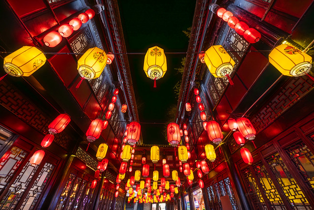 Red and yellow Chinese lanterns with Sichuan opera faces illuminated at night