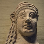 Etruscan moldmade terracotta female votive head in Philadelphia Late Archaic period, early 5th c. BCE
No archaeological provenience
Of a type known at Veii, using a mold originally designed for creating antefixes

In the collection of, and photographed on display at, the University of Pennsylvania Museum of Archaeology and Anthropology (Penn Museum), Philadelphia, Pennsylvania, USA
Museum Purchase; Subscription of John Wanamaker, 1896
Inv. MS 1830

&lt;a href=&quot;https://www.penn.museum/collections/object/86392&quot; rel=&quot;noreferrer nofollow&quot;&gt;www.penn.museum/collections/object/86392&lt;/a&gt;