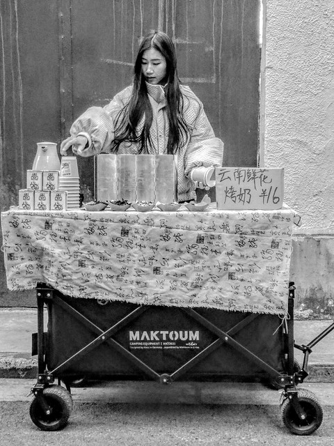 A girl who set up a stall in a deep alley selling Yunnan flower caramel milk tea