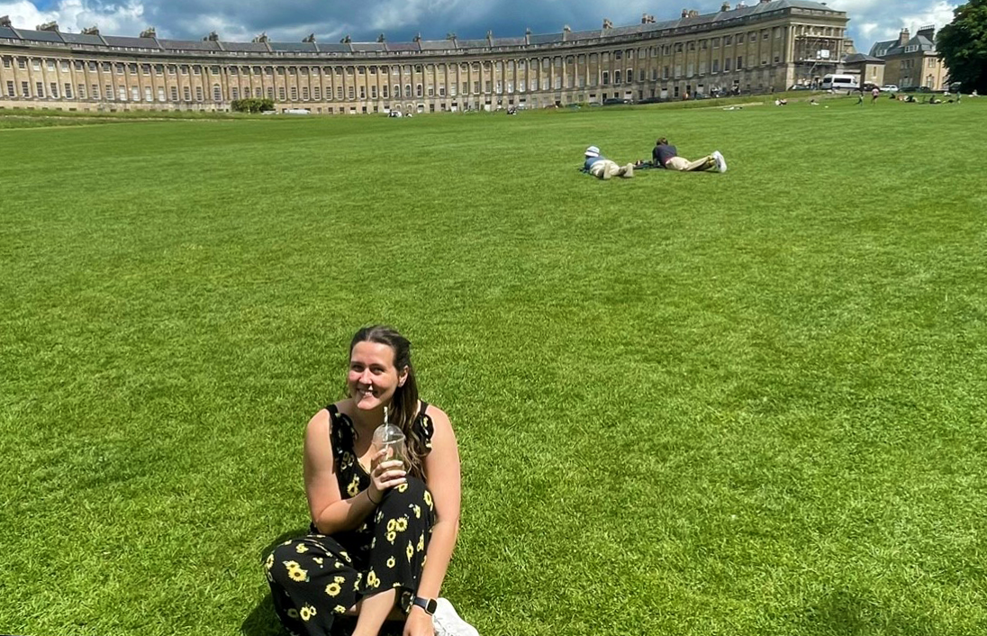 A photo of Nina sitting on the lawn at the Royal Crescent.