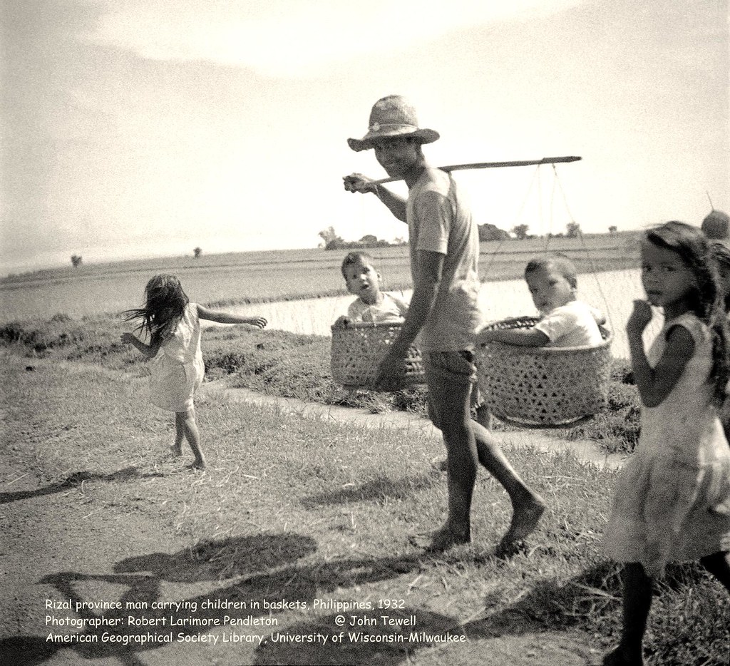 Rizal province man carrying children in baskets, Philippines, 1932