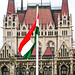 1956 Revolution Flag with a hole in its center flies in front of the Hungarian Parliament, Budapest, Hungary