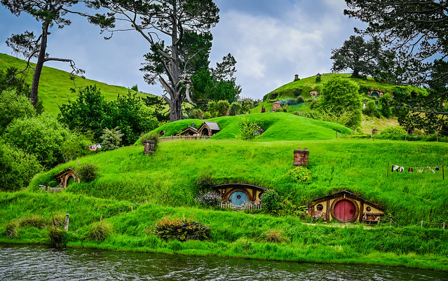 Hobbiton Water's Edge with Hobbiton Hill and Hobbit holes at Hobbiton Movie Set - Matamata New Zealand