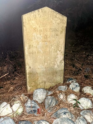 gravestone with seashells at the base at night