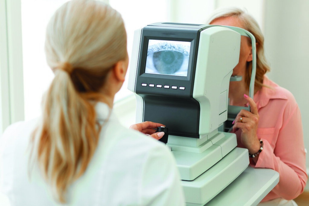 Focused ophthalmologist using computer technologies while screening