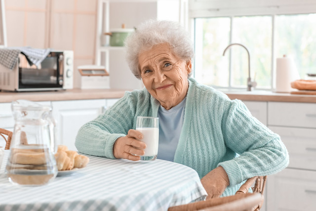 Senior woman with glass of milk in kitchen