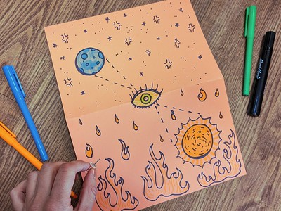 orange paper with a drawing of sun and moon and fire and stars