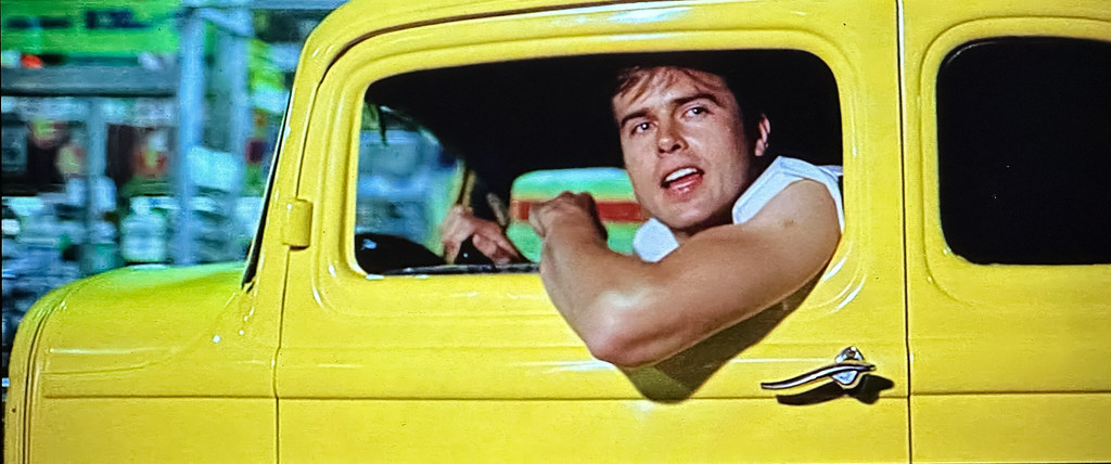 “American Graffiti” (Universal Pictures, 1973),  Hot rodder John Milner (played by Paul Le Mat) in his yellow Deuce Coupe.