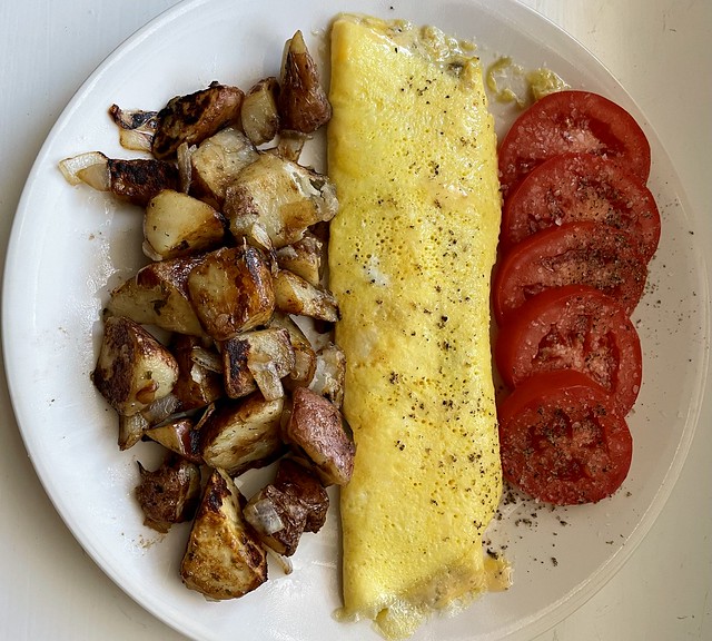 Cheese omelette with potatoes and sliced tomato