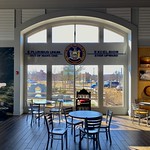 February 18, 2023: New York State seal and mottos on interior of window, Finger Lakes Welcome Center, Geneva, New York At the Finger Lakes Welcome Center in Geneva, New York, a large window in the main hall is decorated with the New York state seal and the state&#039;s and country&#039;s official mottos.