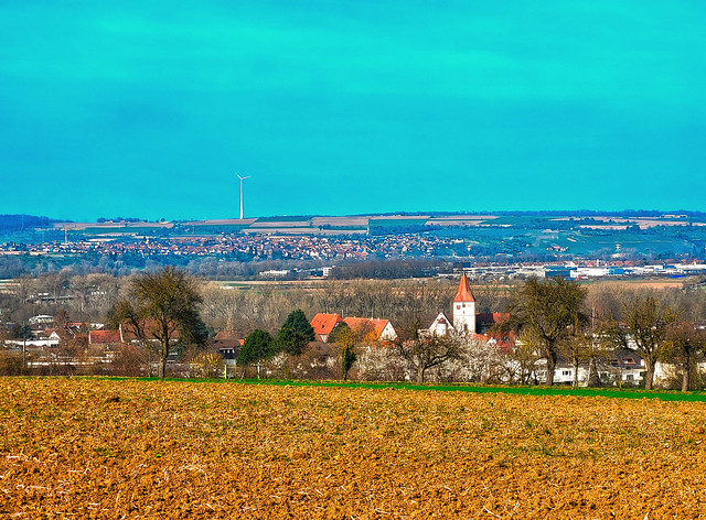 Landschaft mit Kirchturm und Windrad