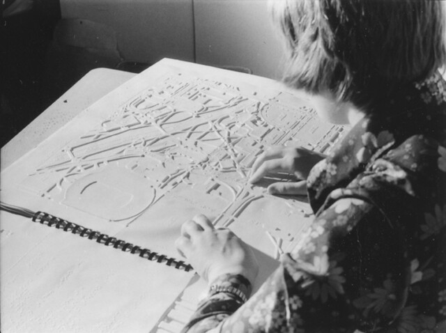 Student using a braille map of MSU campus, 1974