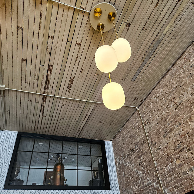 Blend of #oldandnew ... #coffeeshop #oldbuilding #copper #window #wallpaper #lighting #pendantlights #brick #lath #ceiling #brickwall