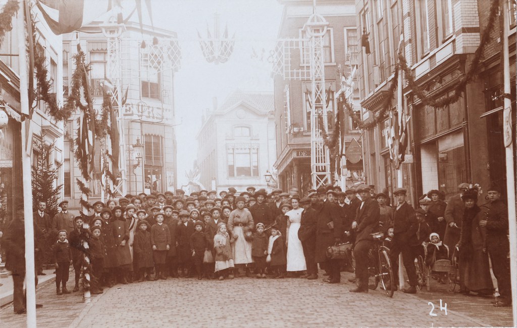 Fotokaart - Feest 1814-1914, ereboog versierde Hoogstraat met grote groep mensen, De Beurs (foto nr. 24)