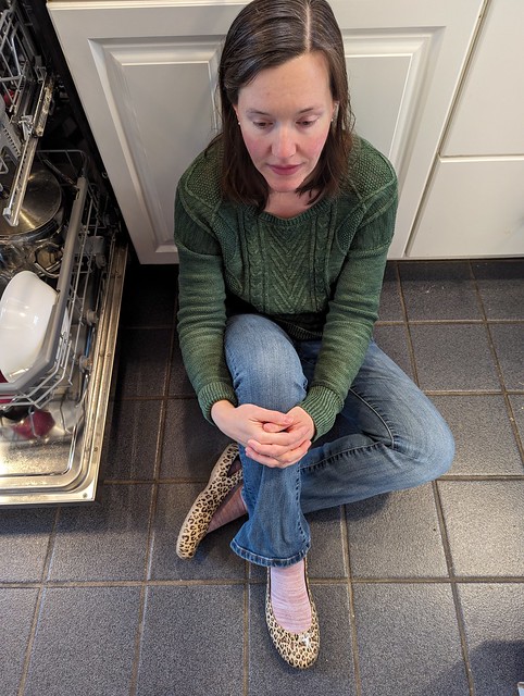 Sitting on the kitchen floor.