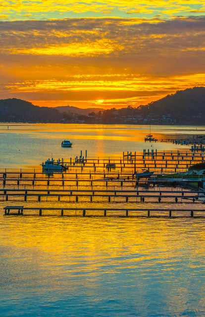 Golden Hour Sunrise over the water with boats and wharves