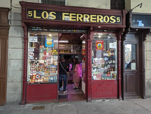 A small storefront with a sign above reading "Los Ferreros". The windows of the store are full