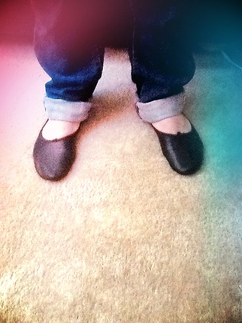 Cuffed blue jeans wearing black ballet slippers