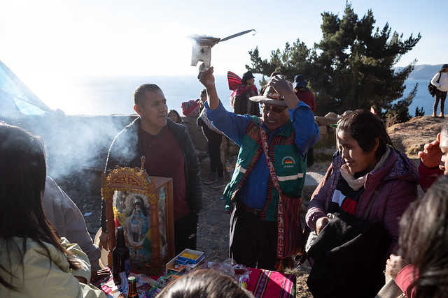 A curandero performs a ceremony for a family, on Cerro Calvario in Copacabana, Bolivia.