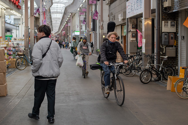 bicycle riders in a shopping street