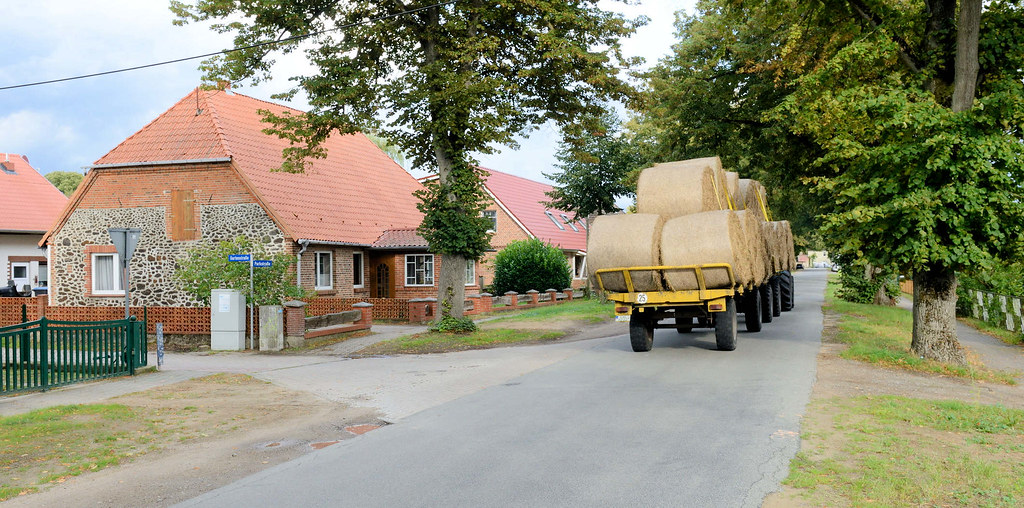 7857 Wohnhaus mit Raseneisenstein, Trecker mit Heuballen in der Parkstraße - Fotos von Warlow, Gemeinde im Landkreis Ludwigslust-Parchim in Mecklenburg-Vorpommern.