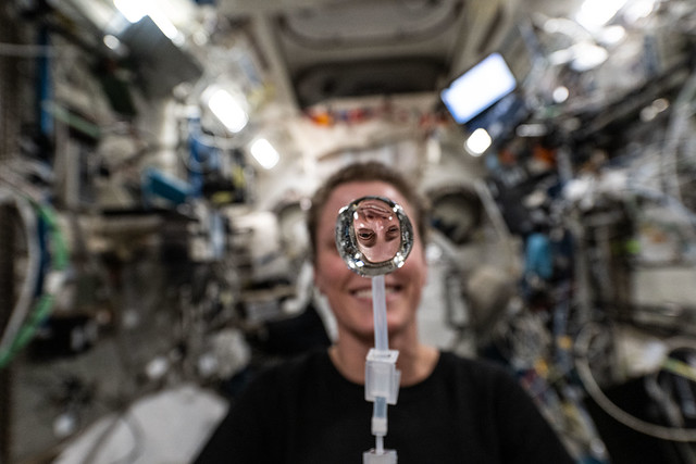 NASA astronaut Loral O'Hara's image is refracted in a water bubble